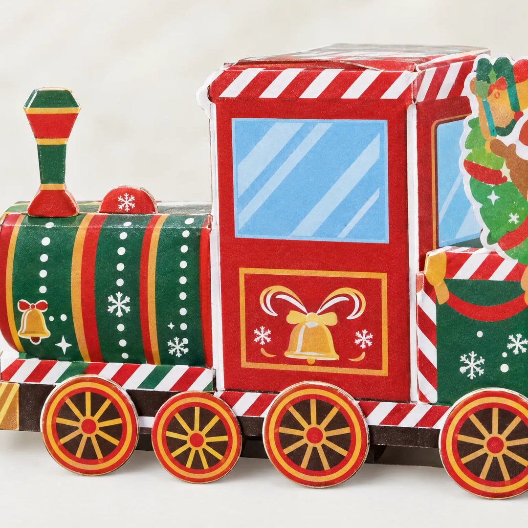 Close-up van de locomotief met rode cabine, groene ketel, gouden bel en rode wielen, gemaakt van bedrukt karton. 3