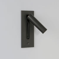 Donkere wandlamp met brandende led in de uitgeklapte lichtbuis, tegen een lichte muur 6