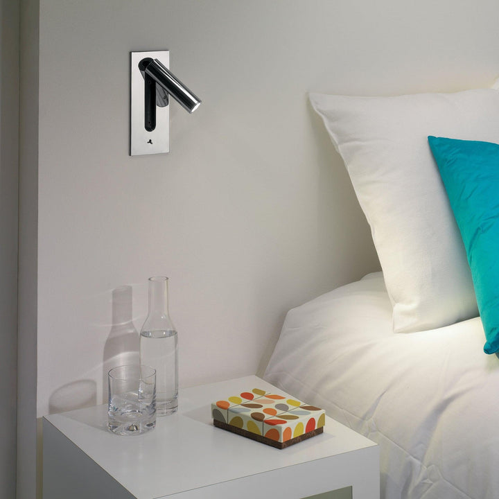 Wandlamp met brandende led en draaibare lichtbuis naar rechts, op een rechthoekige bronskleurige plaat 9