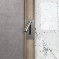 Wandlamp in geborsteld nikkel, ingebouwd in een houten strook tussen stof en wit marmer 33