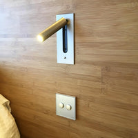 Wandlamp met gouden spot ingebouwd in een houten wand, met een tweevoudige drukschakelaar eronder 29