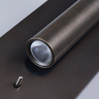 Close-up van de lichtbuis met honingraatlens en het metalen tuimelschakelaartje op de bronzen plaat 18