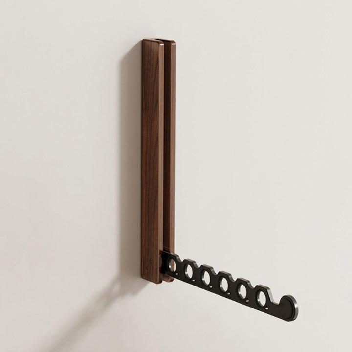 Donkerhouten wandkapstok met uitgeklapte zwarte metalen arm met ronde gaten, schuin van opzij gezien tegen een lichte muur. 6