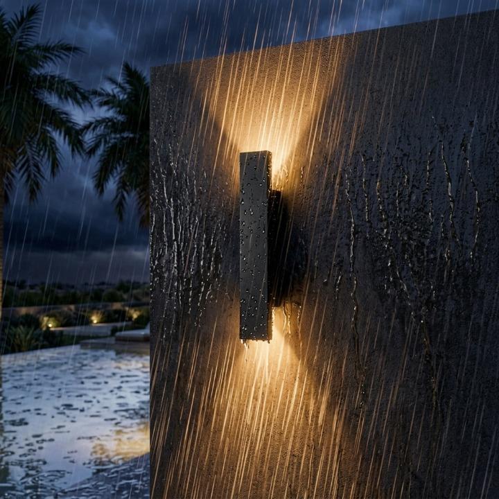 Zwarte wandlamp brandt op een muur in hevige regen, ter illustratie van de waterbestendigheid 9