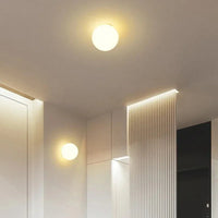 Twee bollampen, een aan het plafond en een aan de wand, naast een gegroefd wandpaneel 10