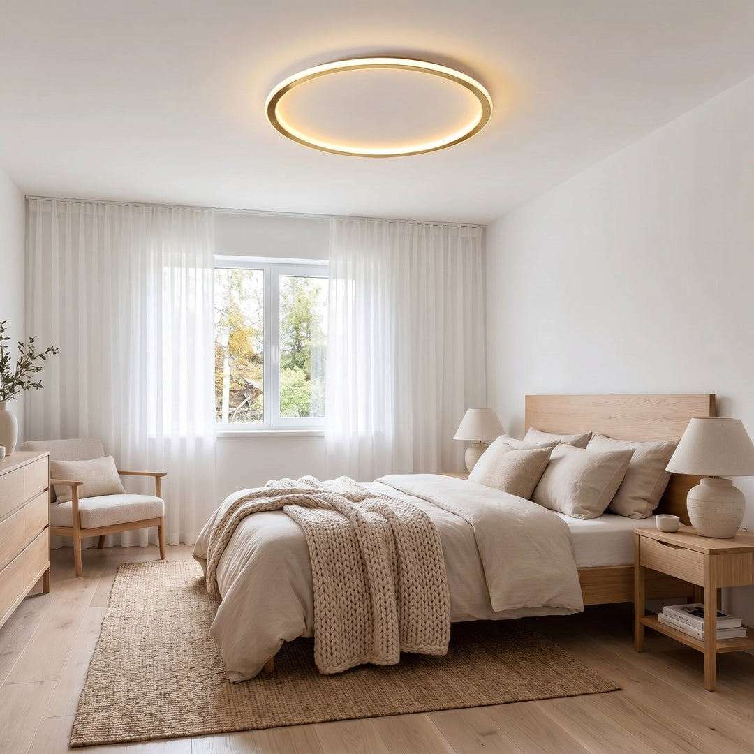 Ronde gouden plafondlamp boven een bed in een lichte slaapkamer met houten meubels 5