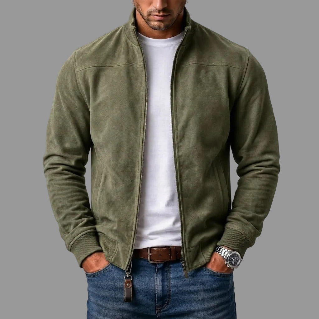 Man draagt de olijfgroene suèdelook jack open over wit T-shirt en spijkerbroek, met leren sleutelhanger aan de rits. 3