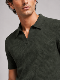 Close-up van de kraag, V-hals en fijne structuur van het donkergroene gebreide poloshirt 12