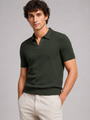 Donkergroen gebreid poloshirt met V-kraag, voorkant, gedragen door een model met crèmekleurige broek 11