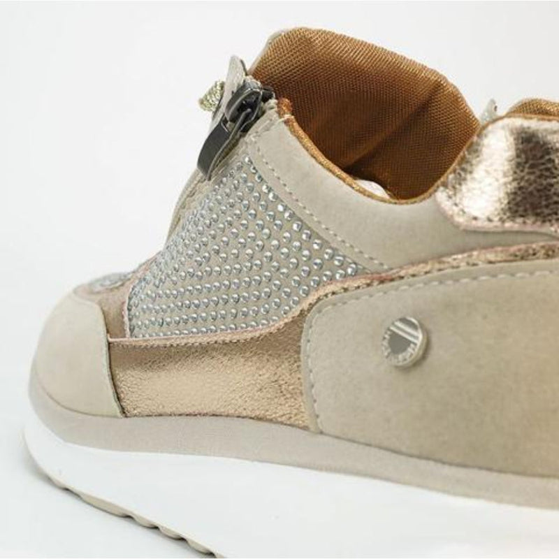 Detail van de hiel en zijkant van een beige sneaker met zijrits, strassteentjes, metallic bies en bruine binnenvoering. 9