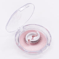 Open rond doosje met doorzichtig deksel op een witte achtergrond, met een paar wimpers op een houdertje op roze glitterbodem. 6