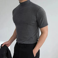 Model draagt het donkergrijze shirt met korte mouwen en opstaande boord, met een hand in de zak van een zwarte broek. 3