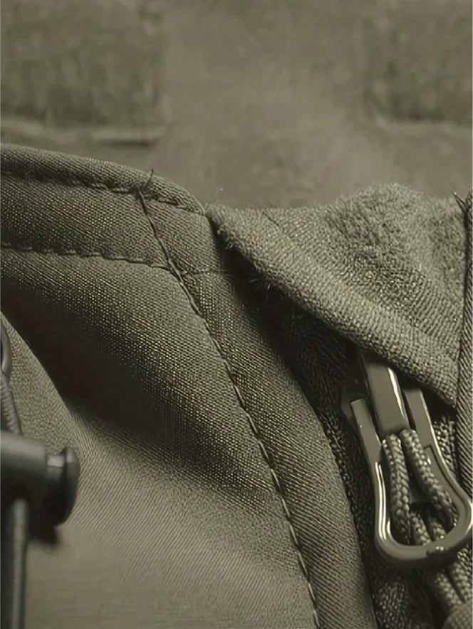 Close-up van de olijfgroene jas met stiknaad, kraag met zachte voering en ritstrekker met koordje. 8