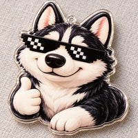 Close-up van een los transparant acryl ornament: een lachende husky met pixelzonnebril en een duim omhoog, op een grijze stoffen ondergrond. 4