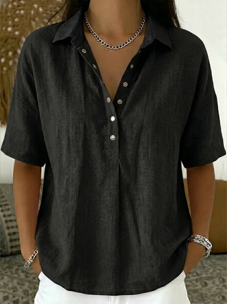 Blouse in zwart gedragen door een model, met kraag, knoopdetails en een schakelketting 6