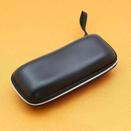 Zwart kunstleren brilkoker met witte rits en kleine lus op een oranjegele achtergrond 11