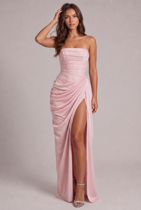 Roze versie van de jurk, voorkant, model raakt haar haar aan, hoge split en sandalen 5