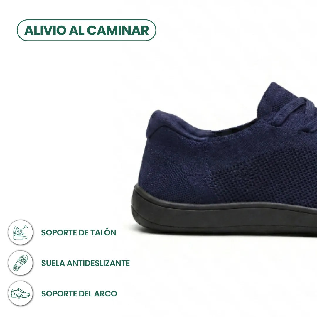 Detail van de hiel en zool van de marineblauwe gebreide sneaker met zwarte zool, met pictogrammen voor hielsteun en antislip. 22