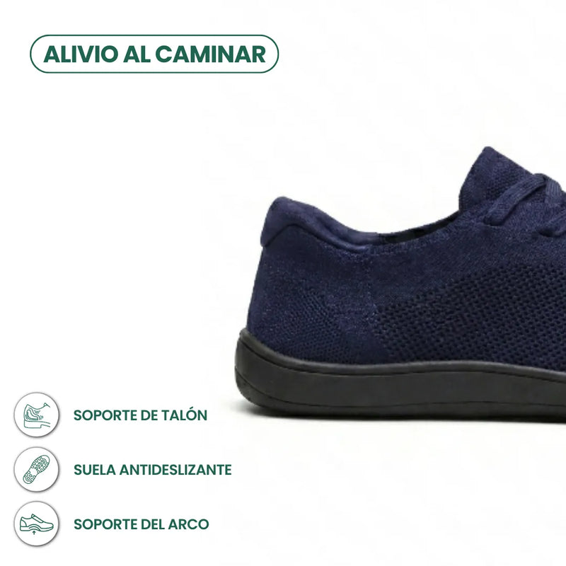 Detail van de hiel en zool van de marineblauwe gebreide sneaker met zwarte zool, met pictogrammen voor hielsteun en antislip. 22