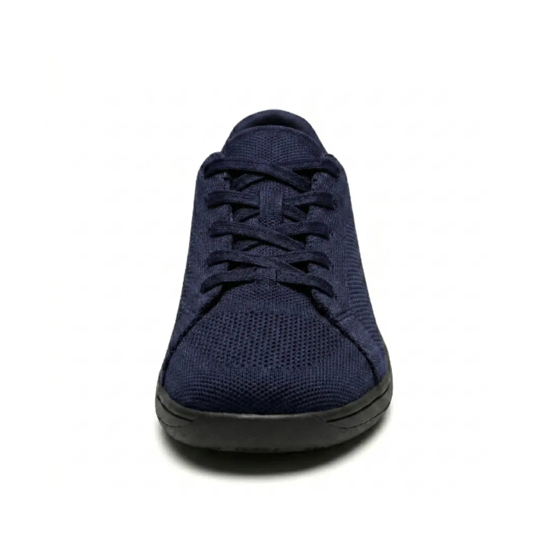 Marineblauwe gebreide sneaker met zwarte zool, recht van voren gefotografeerd, met veters en brede ronde neus. 26