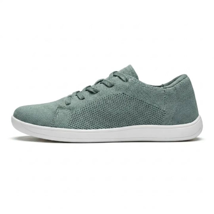 Zijaanzicht van een groene gebreide sneaker met witte zool, veters en geperforeerd gaaspaneel aan de zijkant. 28