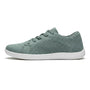 Zijaanzicht van een groene gebreide sneaker met witte zool, veters en geperforeerd gaaspaneel aan de zijkant. 28