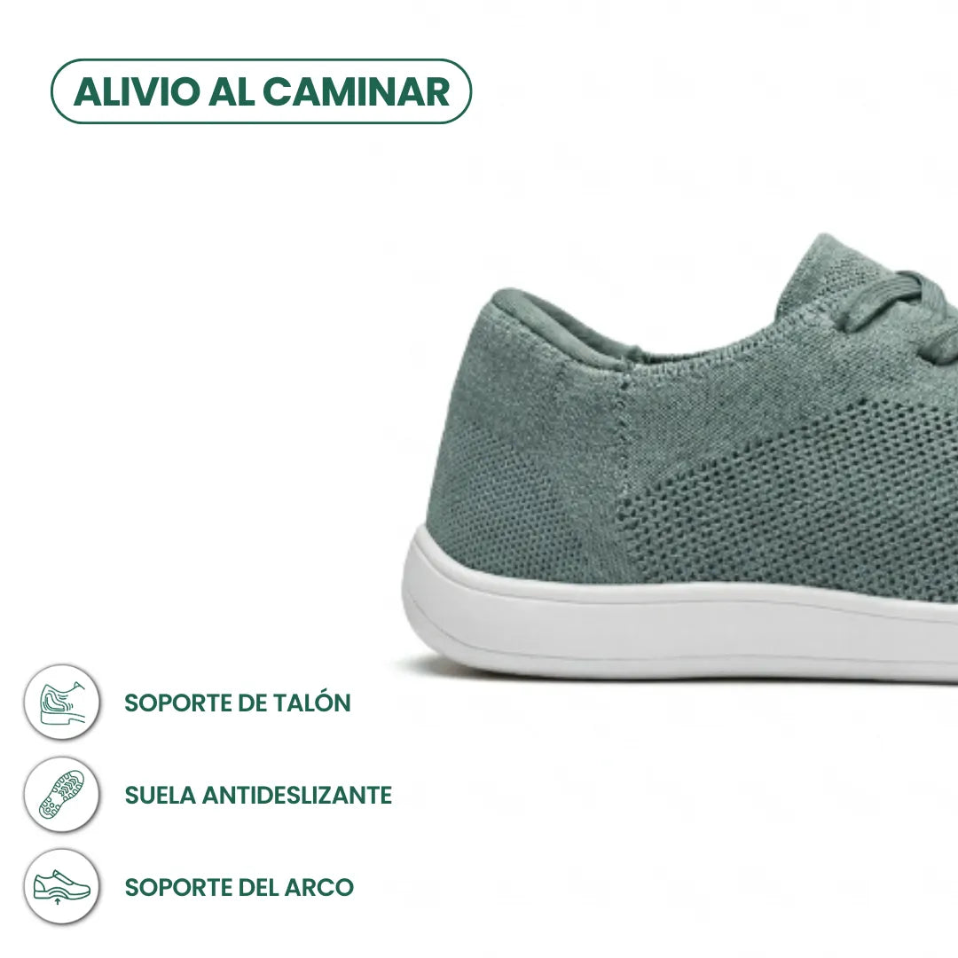 Detail van de hiel en zool van de groene gebreide sneaker met witte zool, met pictogrammen voor hielsteun en antislip. 31