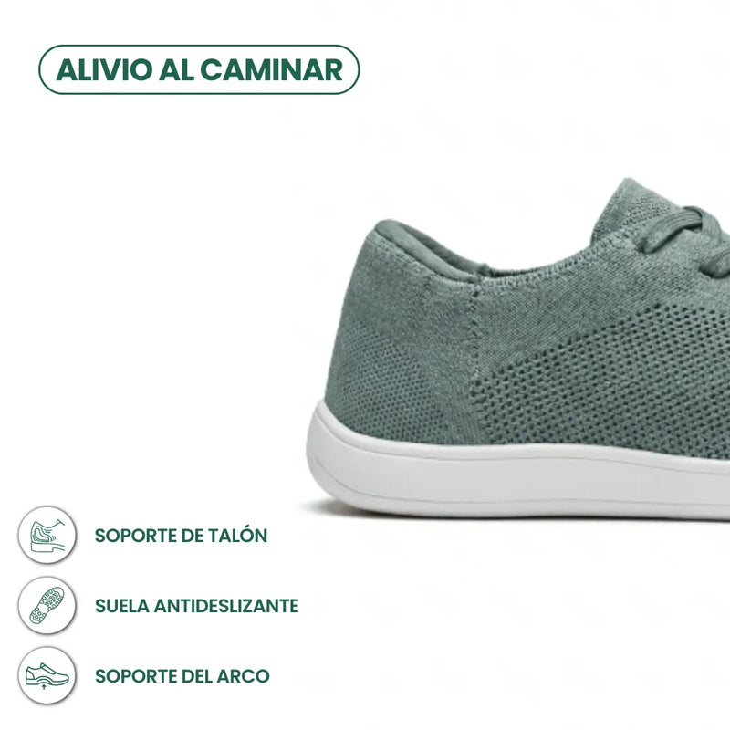 Detail van de hiel en zool van de groene gebreide sneaker met witte zool, met pictogrammen voor hielsteun en antislip. 31