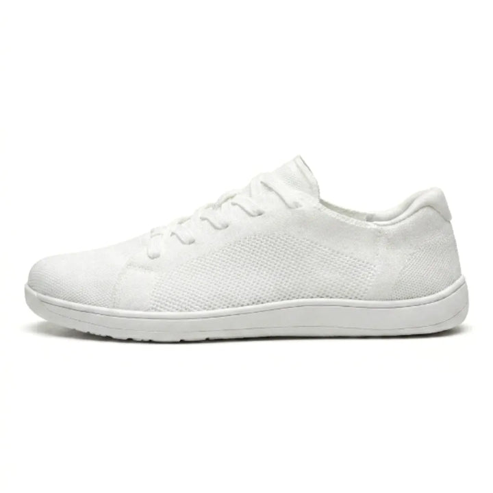 Zijaanzicht van een witte gebreide sneaker met witte zool, veters en geperforeerd gaaspaneel aan de zijkant. 37