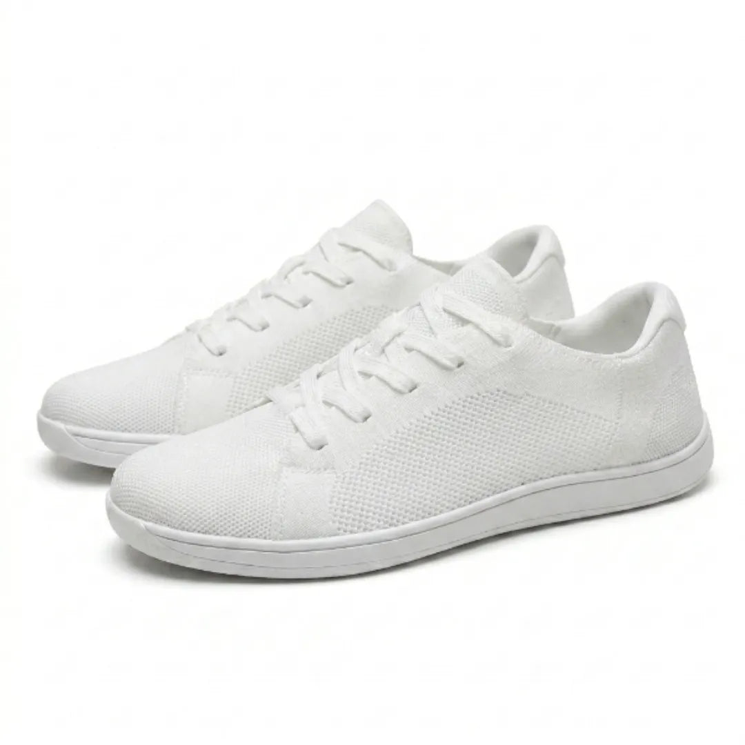 Een paar witte gebreide sneakers met veters, schuin van opzij gefotografeerd op een witte achtergrond. 43