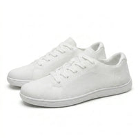 Een paar witte gebreide sneakers met veters, schuin van opzij gefotografeerd op een witte achtergrond. 43