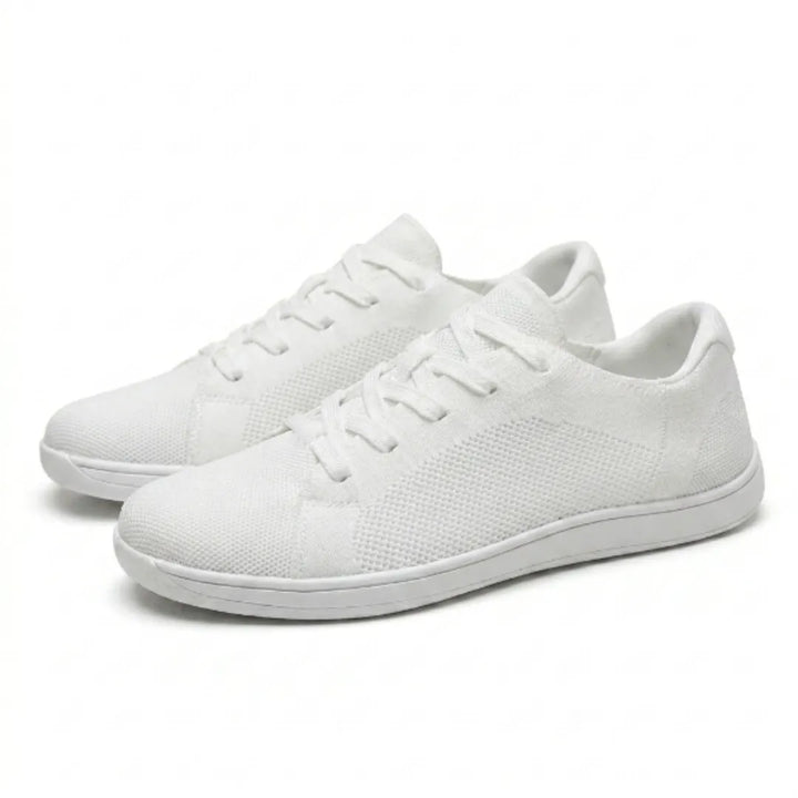 Een paar witte gebreide sneakers met veters, schuin van opzij gefotografeerd op een witte achtergrond. 43