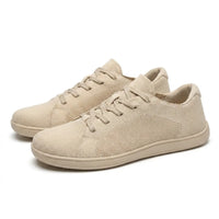 Paar beige gebreide sneakers schuin van voren, met veters en effen beige zolen op een witte achtergrond. 7