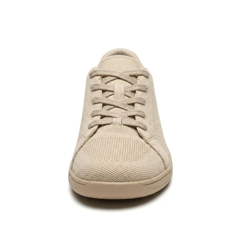 Beige gebreide sneaker van voren, met gekruiste veters en de brede, afgeronde neus goed zichtbaar. 8