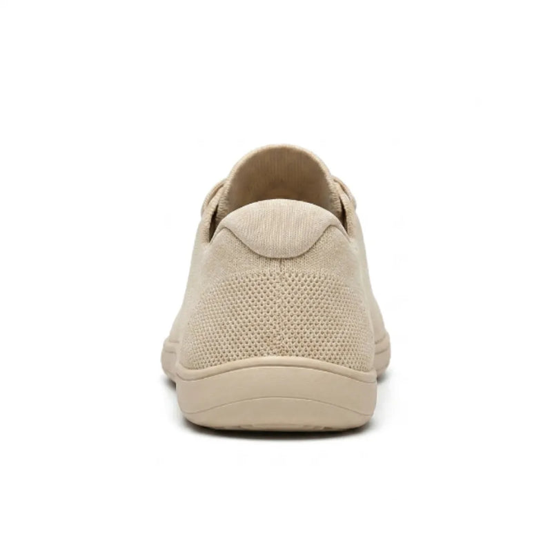 Beige gebreide sneaker van achteren, met het gaasdetail op de hiel en de brede, vlakke zool. 9