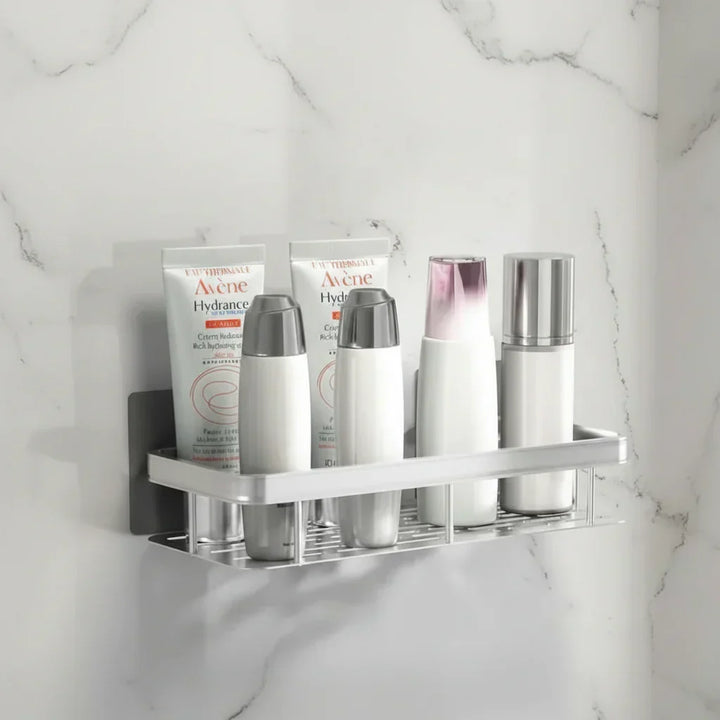 Zilverkleurige plank op lichte marmerwand met witte tubes en flesjes verzorgingsproducten 7