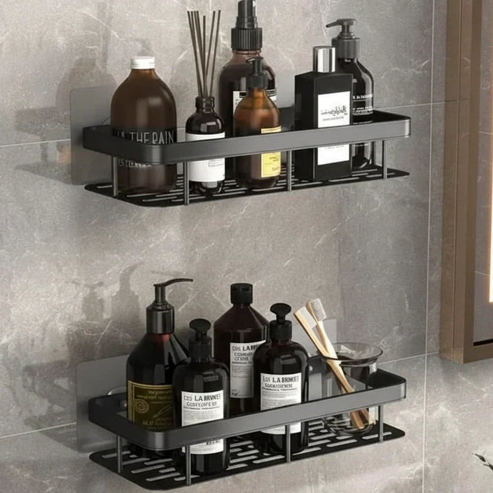 Twee zwarte planken met gaatjesbodem boven elkaar, gevuld met flessen en een bekertje met tandenborstels 9