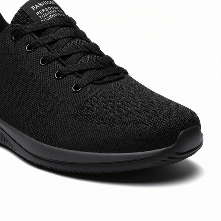 Close-up van de voorkant van een zwarte gebreide sneaker met veters en luchtige gaatjes 7