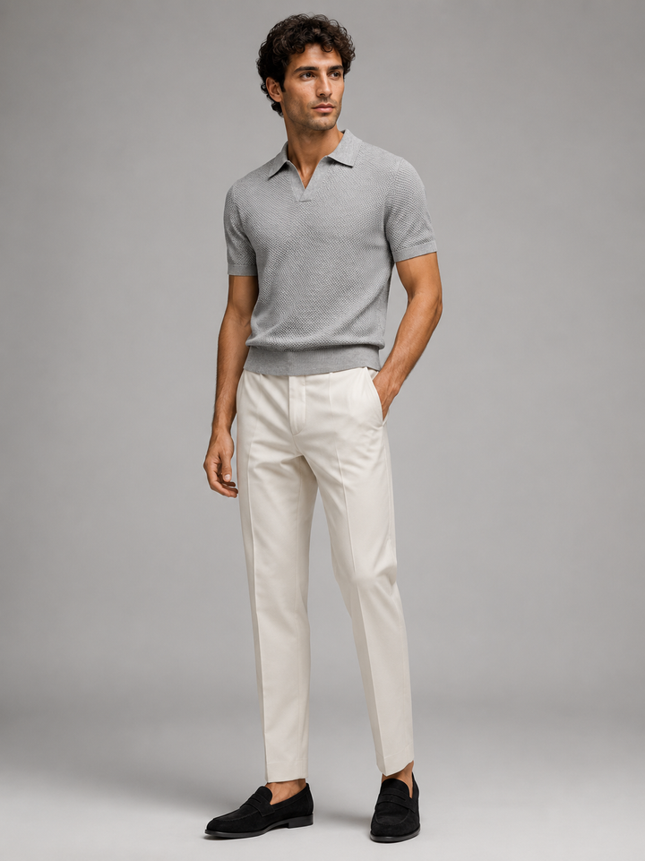 Volledig lichaam, grijs poloshirt met crèmewitte pantalon en zwarte loafers, zijwaarts kijkend 28