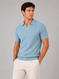 Model draagt het lichtblauwe gebreide poloshirt met open V-kraag, voorkant, gecombineerd met crèmekleurige broek op grijze 1