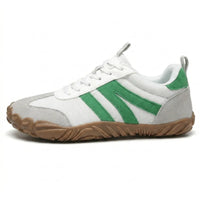 Zijaanzicht van een witte sneaker met groene strepen, grijs suède en bruine profielzool. 28