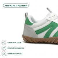 Zijaanzicht van de hiel van een witte sneaker met groene strepen en bruine zool, met pictogrammen. 31