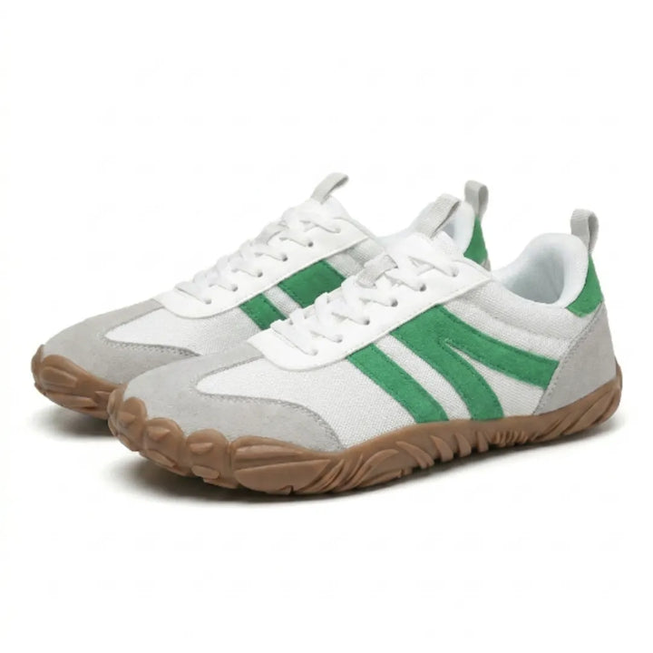 Paar witte sneakers met groene strepen en grijs suède, schuin van voren gezien op een witte achtergrond. 34