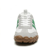Voorkant van een witte sneaker met groene strepen, witte veters en brede bruine rubberen neus. 35