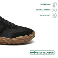 Close-up van de brede neus van een zwarte barefoot sneaker met veters en bruine zool, met pictogrammen. 23