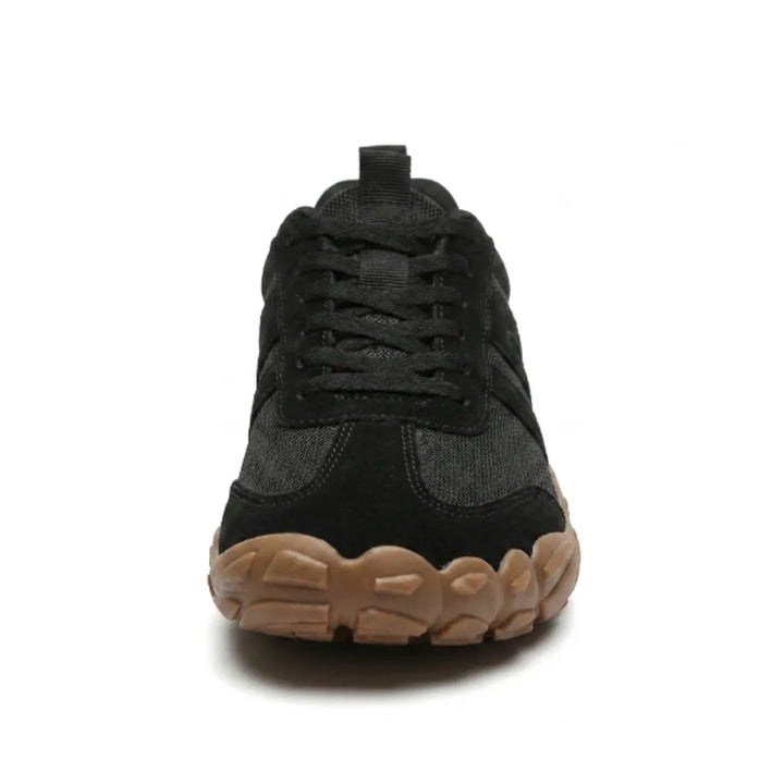 Voorkant van een zwarte barefoot sneaker met veters en brede, afgeronde bruine rubberen neus. 26