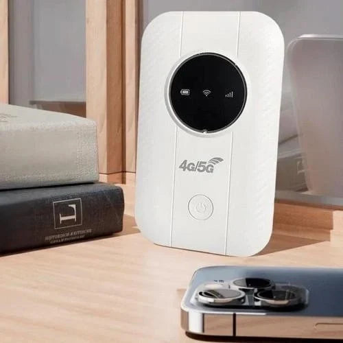 Witte router staat rechtop op een houten plank naast boeken en een smartphone met drie camera's 3