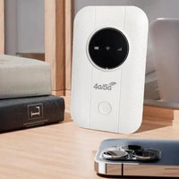 Witte router staat rechtop op een houten plank naast boeken en een smartphone met drie camera's 3