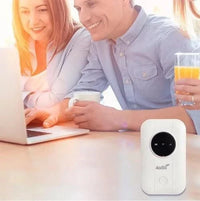Witte router op tafel, op de achtergrond kijken een lachend stel en een vrouw met sap naar een laptop 4