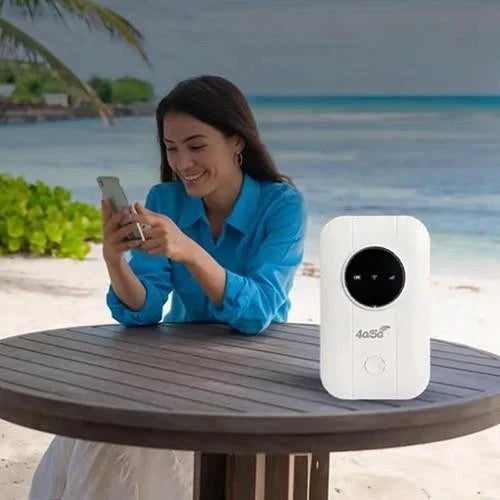 Witte router op een houten tafel op het strand, terwijl een lachende vrouw op haar telefoon kijkt 6